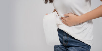 Asian woman has diarrhea, She carried toilet paper and touched her stomach. With isolated white background.